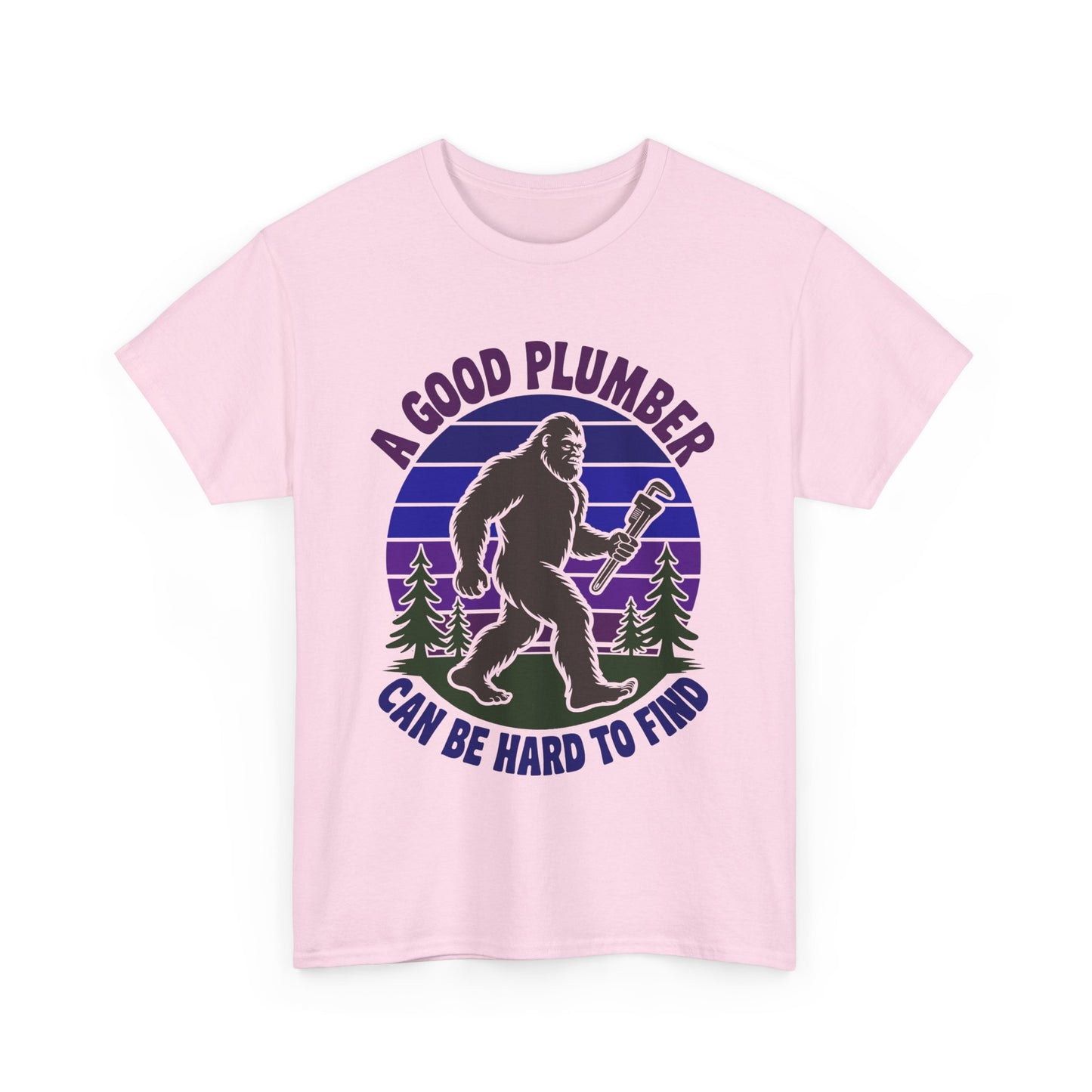 Pink t-shirt with a graphic of a bigfoot-like creature holding a wrench and text 'A Good Plumber Can Be Hard to Find' on a white background.