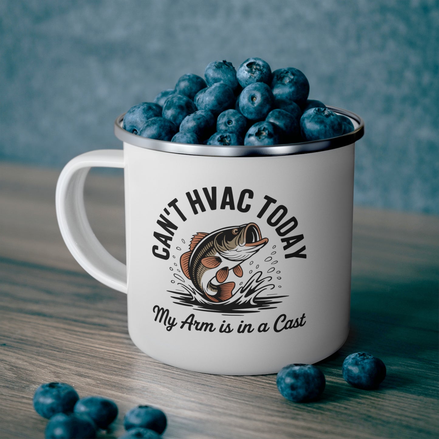 White mug with blueberries and humorous HVAC themed fishing graphic on a wooden surface