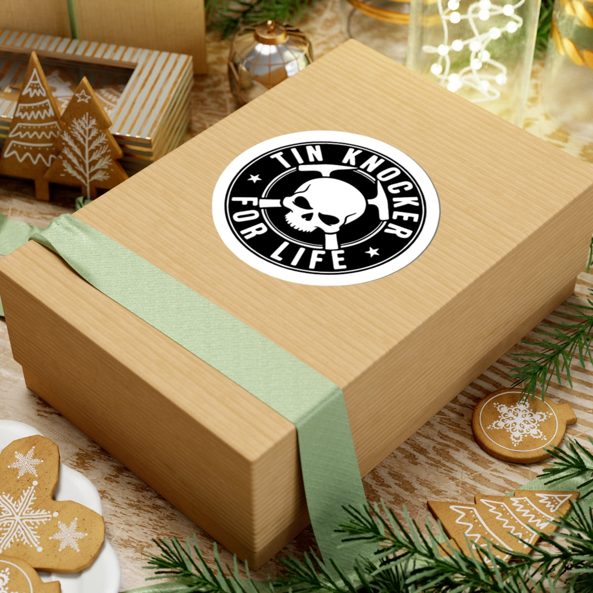 Wooden gift box with a green ribbon and 'Tin Knocker for Life' sticker on a festive background.