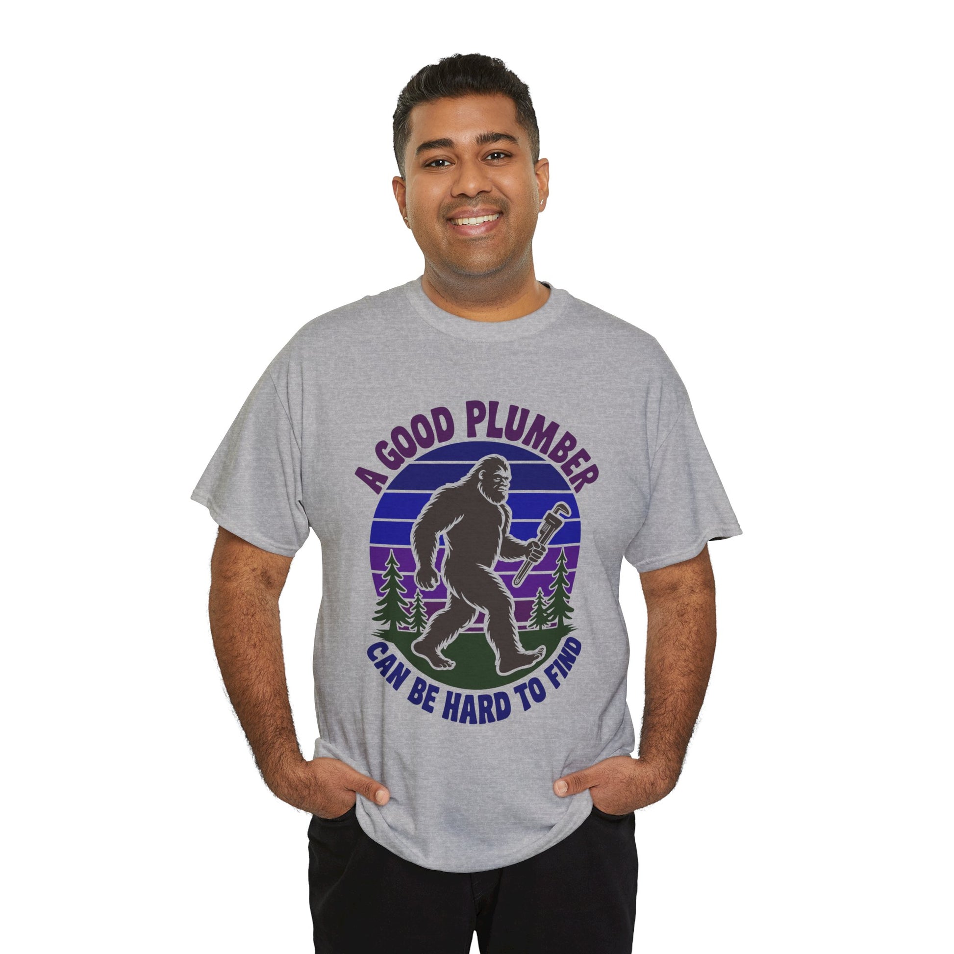 Man wearing a Gray t-shirt with a graphic of a bigfoot-like creature holding a wrench and text 'A Good Plumber Can Be Hard to Find' on a white background.