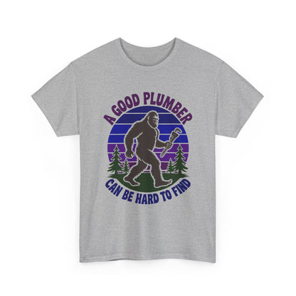 Gray t-shirt with a graphic of a bigfoot-like creature holding a wrench and text 'A Good Plumber Can Be Hard to Find' on a white background.